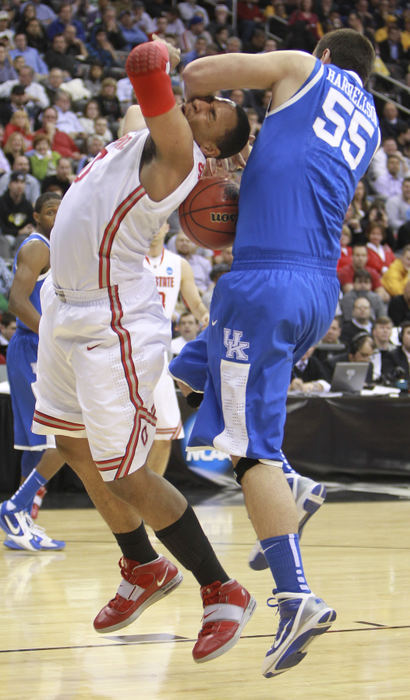 Story - 3rd place - Kentucky Wildcats forward Josh Harrellson (55) forces a jump ball as he blocks Ohio State Buckeyes forward Jared Sullinger (0) in the first half of their NCAA regional tournament game at the the Prudential Center. (Neal C. Lauron / The Columbus Dispatch)