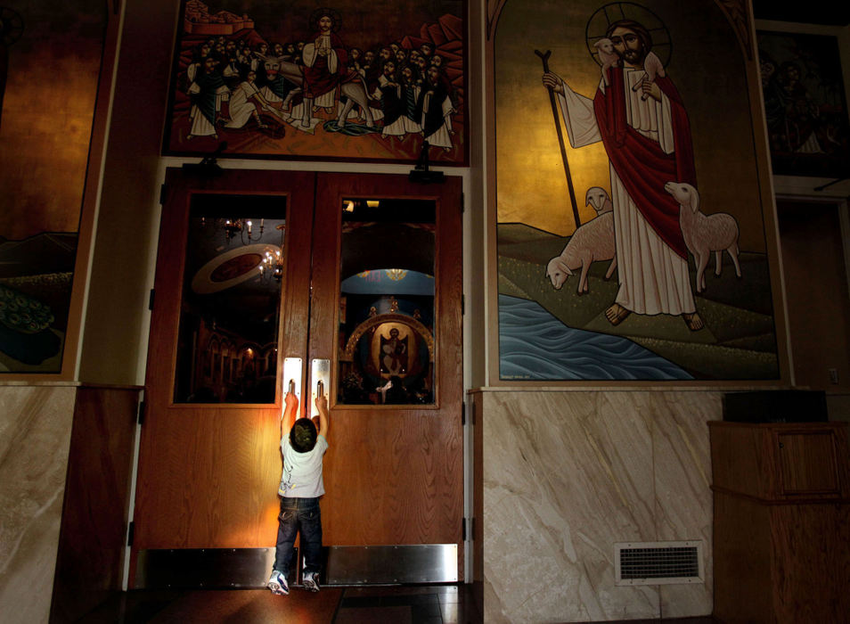 Feature - 1st placeFady Ghobrial , 2, tries to reach the door handles to get into the sanctuary where a memorial Mass at St. Mark Coptic Orthodox Church in Seven Hills is being held for Coptic Pope Shenouda III.  Pope Shenouda, 88, died Saturday in Egypt. The 88-year-old pope had served for 41 years. He had visited Cleveland and St. Mark many times. (Lisa DeJong / The Plain Dealer)