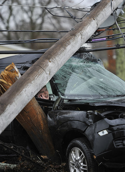 Spot News - 1st placeA driver talks on his cell phone as he waits to be rescued from his crashed car after striking a utility pole on South Bird Road. Rescue personnel were unable to remove the driver, who was not injured, from the car because the lines and transformer laying on top of the car still had power flowing through them.The driver was trapped for nearly a half hour while Ohio Edison crews cut the power and secured the pole.   (Bill Lackey / Springfield News-Sun)