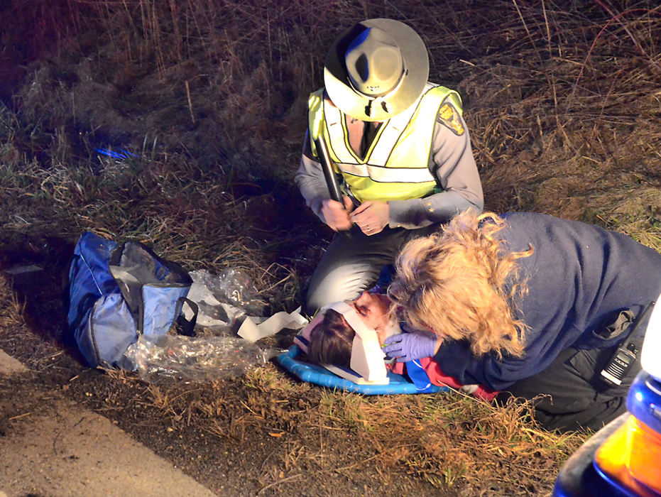 Spot News - 2nd placeColumbiana EMS paramedic Kelli Harding tends to 19-year-old April Fulcomer after an accident on state Route 517 east of Lisbon. Fulcomer and the driver, Leticia Lujan, 20, of Lisbon were transported to St. Elizabeth's Hospital in Youngstown. According to highway patrol trooper Mike Smith, the 2000 Ford Taurus was westbound at about 2:15 a.m., went off the left side of the road, up an embankment and into a wire pasture fence. The car flipped end over end and ended up on its roof. The two were able to get out of the car and made their way back to the road where they called for help, using a nearby railroad crossing sign to identify their location.  (Patricia Schaeffer / The (Lisbon) Morning Journal)