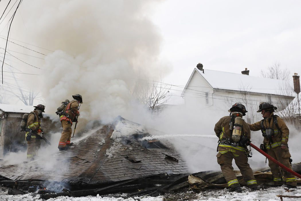 Spot News - 2nd placeColumbus firefighters work to extinguish a garage fire behind a Chicago Avenue home in Franklinton. According to Columbus Fire the home appears vacant and the garage collapsed when the first crews arrived.  (Eamon Queeney / The Columbus Dispatch)