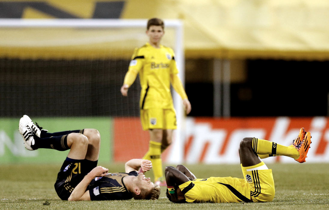 Sports Feature - HM - Philadelphia Union forward Aaron Wheeler (12) and Columbus Crew forward/midfielder Dominic Oduro (8) lay on the field after colliding in mid-air chasing a header during the second half of their MLS soccer game at Crew Stadium in Columbus. The Columbus Crew won its home-opener against the Philadelphia Union, 2-1.  (Sam Greene / The Columbus Dispatch)