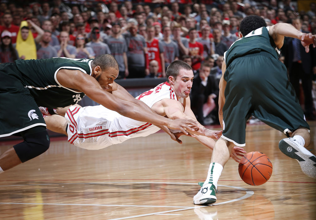 Sports - 1st place - Michigan State guard Travis Trice (20) grabs the ball as Ohio State guard Aaron Craft (4) tries to dive for it in the second half of their game at Value City Arena in Columbus. The Buckeyes defeated the Michigan State 69 - 67. (Eamon Queeney / The Columbus Dispatch)