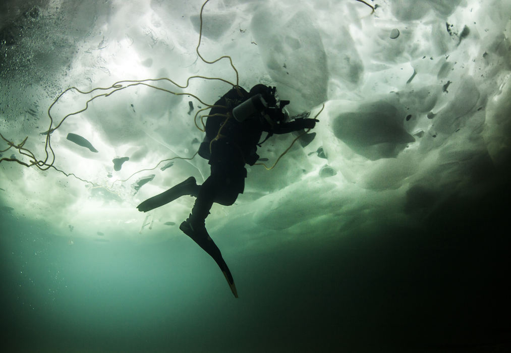    Story - 1st place - Rich Synowiec swims beneath 20 inches of Lake Erie ice during a dive in Colchester, Ontario.  (Andy Morrison / The (Toledo) Blade)