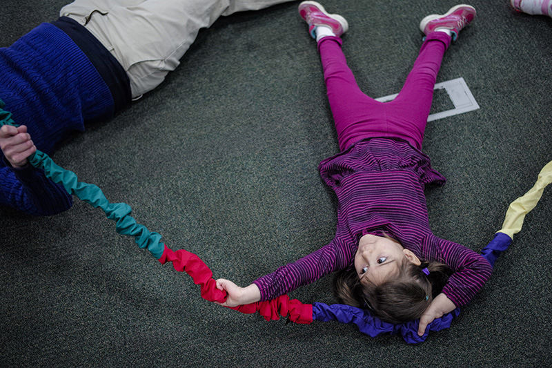 Feature - HM - Anna Allen, 4, stretches back while holding a stretchy hoop during preschool storytime at the Delaware County District Library. (Joshua A. Bickel / ThisWeek Community News)