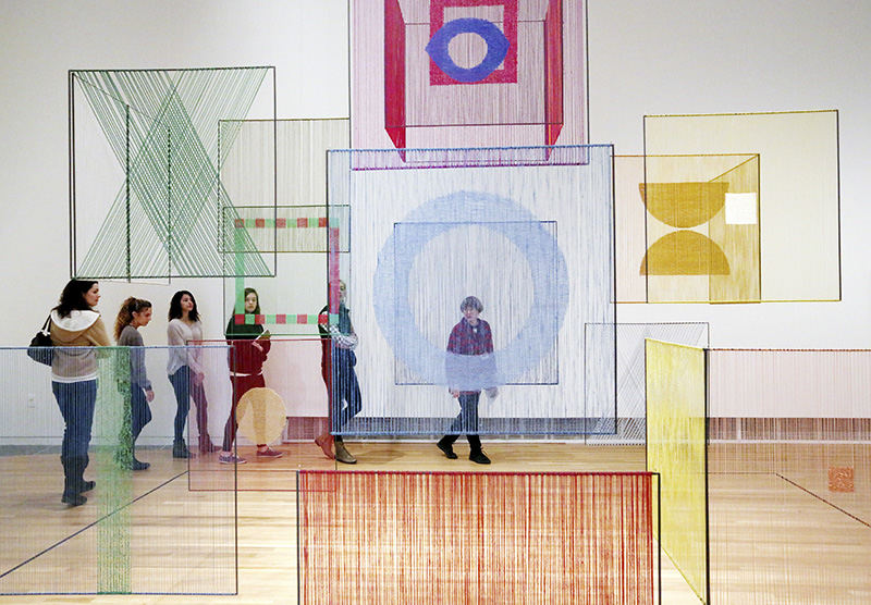 Feature - HM - Docent Patricia Pound, center of photo, leads a group of students from a digital art class during a tour of a show called, "Fiber: Sculpture 1960-Present," at the Wexner Center for the Arts at The Ohio State University. They are walking around a piece called "Element spatial (Spatial Element)" by artist Elsi Giauque, which is made from linen, silk, wool, and metal.  (Fred Squillante / The Columbus Dispatch)