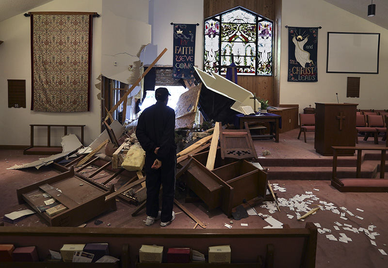 General News - 1st place - John Jones a member of the Asbury North United Methodist Church on Clifton Ave. surveys the damage to the church after a vehicle hit the church. This is the third time the church has been hit by a vehicle and church members said it involved a police chase each time.  (Eric Albrecht / The Columbus Dispatch)