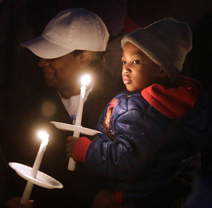 General News - 3rd place - Timothy Pridgen Mayle holds a candle at a vigil for his father Kristopher Mayle who was shot earlier this month in his Canton home on Ohio Ave NE. He is holding Marcia Kyles. (Scott Heckel / The (Canton) Repository)