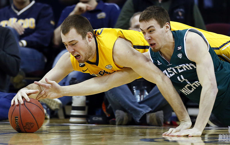    Sports - 3rd place - University of Toledo center Zach Garber (left) scrambles for a loose ball with Eastern Michigan forward Brandon Nazione during the third round of MAC tournament at Quicken Loans Arena in Cleveland. (Jeremy Wadsworth / The (Toledo) Blade)