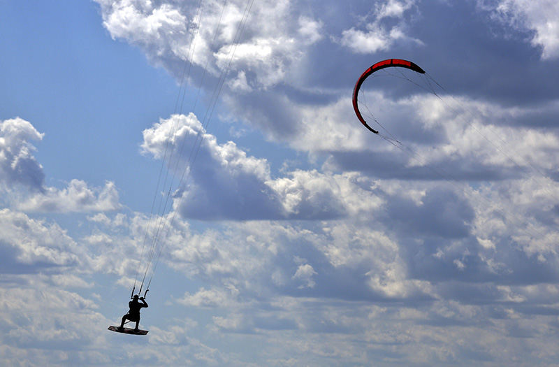 Feature - 1st place - Ron Woodyard and other kite boarders enjoys the winds and blue skys while kiteboarding at Alum Creek State Park. (Eric Albrecht / The Columbus Dispatch)