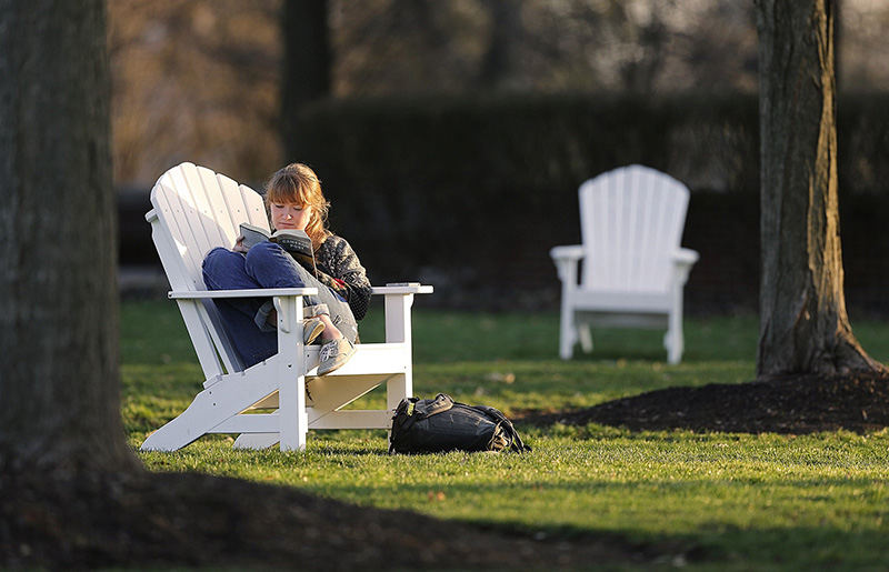 Feature - 3rd place - Otterbein University junior Nora Gallagher takes advantage of well placed Adirondack chairs and the beautiful spring evening to get some class reading in.   (Chris Russell / The Columbus Dispatch)