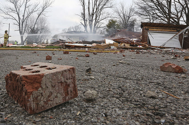 Spot News - 2nd place - Columbus and Hamilton Township firefighters extinguish the last of the flames at this brick home at Stockbridge Road and South Champion that was totally destroyed in an explosion on March 25. (Chris Russell / The Columbus Dispatch)