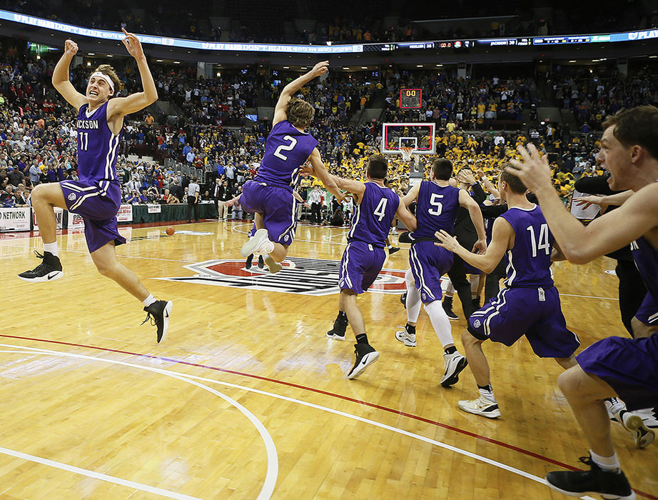 Sports Feature - 2nd place - Jackson's Jaret Pallotta (far left) leaps into the air as his teammates storm the court after defeating Archbishop Moeller in the Division I final game at the Jerome Schottenstein Center in Columbus. Jackson beat Archbishop Moeller 39-38. (Leah Klafczynski / Akron Beacon Journal)