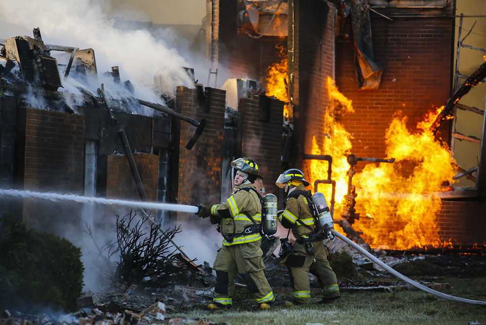 Spot News - 2nd place - Firefighters try to extinguish a fire as gas burns from pipes behind them at Bridgepoint Church on Lewis Avenue in Temperance, Michigan.  (Andy Morrison / The Blade)