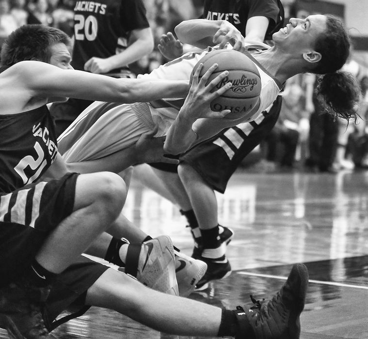    Sports - HM - Bowsher's Marcus Ray (13) bends over backwards to pull in a rebound against  Perrysburg's Seth Morgan (21) during a Division I sectional game in Fostoria. Bowsher defeated Perrysburg 65-42. (Jeremy Wadsworth / The Blade)