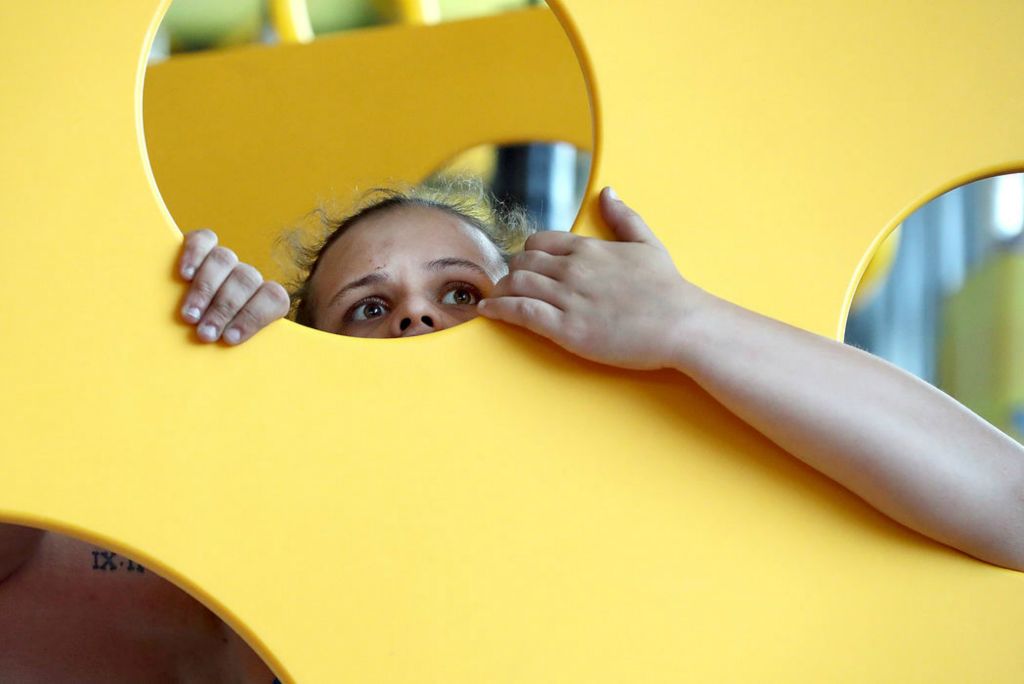 Feature - HM - Tiffani Butcher, of Westerville, clings to a suspended panel as she navigates an obstacle course during a private family and friends night at the new Urban Air Adventure Park in Dublin. (Shane Flanigan / ThisWeek Community News)