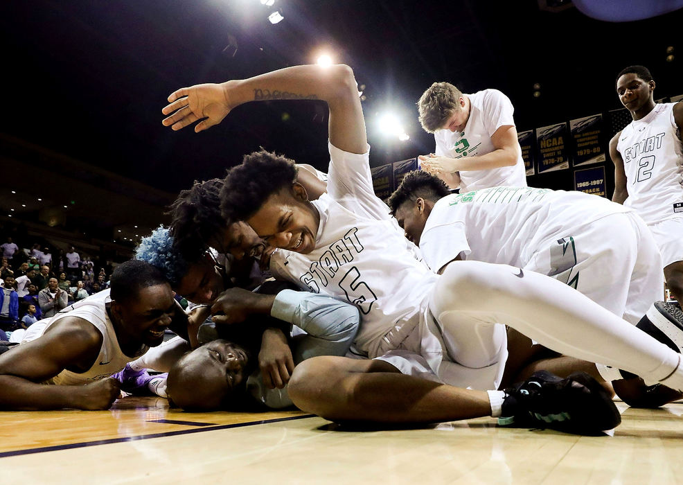 Sports Feature - 2nd place - Start players swarm head coach Matt Wortham after winning 57-53 in an Division I basketball district final game against Sylvania Northview at the University of Toledo's Savage Arena. (Kurt Steiss / The Blade)