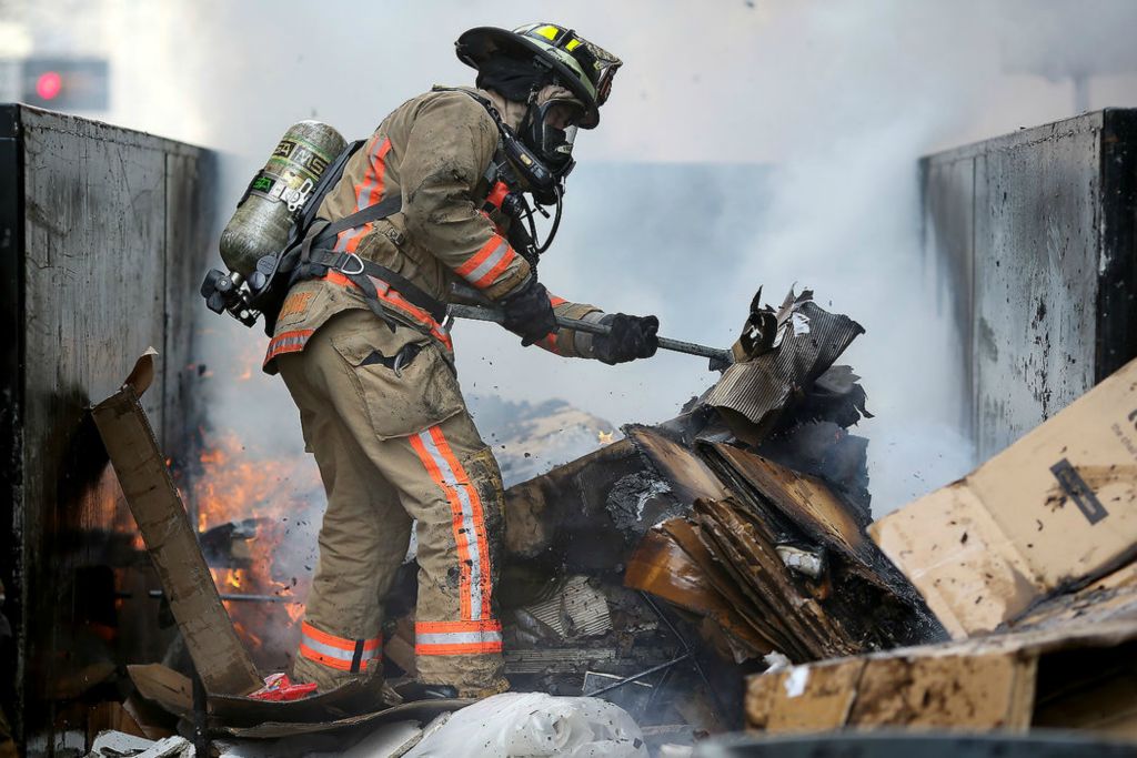 Spot News - 3rd place - Cincinnati firefighters work to extinguish a dumpster fire, in the 300 block of Elm Street in Cincinnati.  (Kareem Elgazzar / The Cincinnati Enquirer)