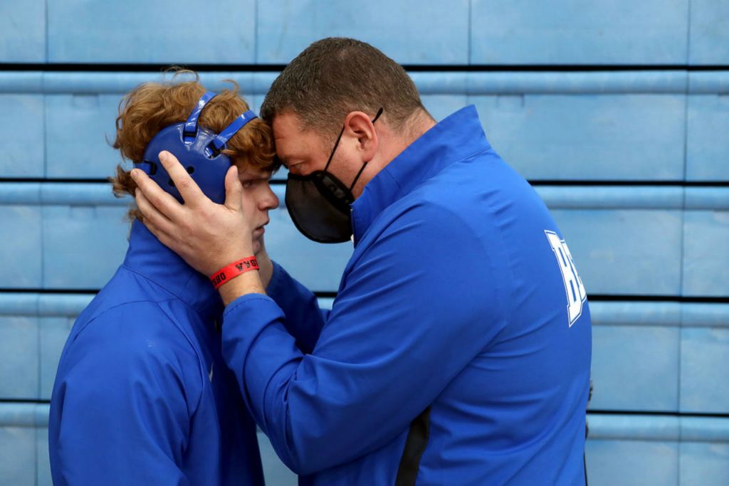 Sports Feature - 1st place - Olentangy Berlin's Caiden Hooks, left, shares a moment with his father and Berlin assistant coach, Jamie Hooks, before his 160-pound consolation match against Vandalia Butler's Matt Motter at the OHSAA Division I state wrestling tournament at Hilliard Darby High School. Caiden, 17, who has Asperger’s syndrome, a form of autism, was diagnosed at 19 months old with bilateral retinoblastoma, a form of eye cancer that resulted in both eyes being removed in 2007. Hooks rallied from a 13-7 deficit in the third period to defeat Motter via pinfall. (Shane Flanigan / ThisWeek Community News)