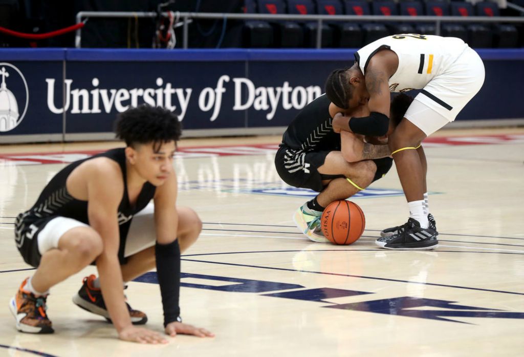 Sports Feature - HM - Centerville's Jayson Hayes consoles Westerville Central's Tasos Cook while Central's Quincy Clark reflects on a 43-42 loss to the Elks in the Division I state championship game at University of Dayton's UD Arena. (Shane Flanigan / ThisWeek Community News)