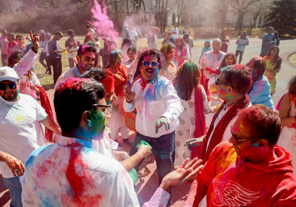 Feature - HM - Bharad Kannan, of Perrysburg, center, dances as people throw colored powder into the air during the Holi festivities at the Hindu Temple of Toledo in Sylvania. (Kurt Steiss / The Blade)