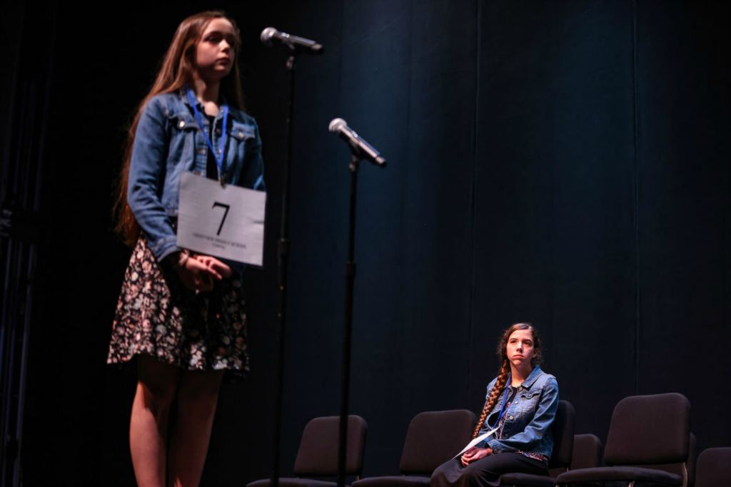 Story - 1st place - Cara McIntosh, from Christian Home Educators of Paulding County, listens as Lainey Gardner, from Crestview Middle School wins the championship round during The Blade Northwest Ohio Championship Regional Spelling Bee at the Owens Community College Performing Arts Center in Perrysburg. (Rebecca Benson / The Blade)