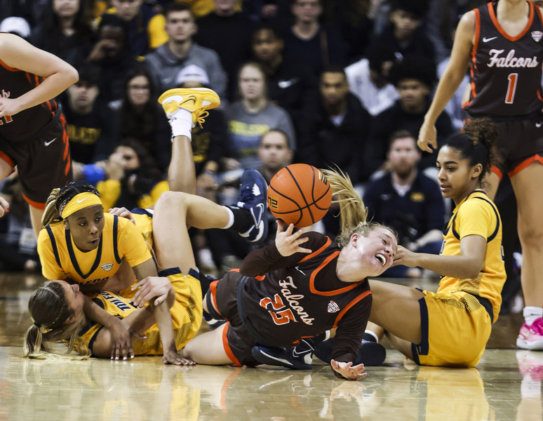 Sports - 2nd place - Bowling Green’s Lexi Fleming passes the ball from the ground after colliding with Toledo players during a MAC basketball game at Savage Arena in Toledo. Toledo defeated Bowling Green, 62-56.  (Rebecca Benson / The Blade)