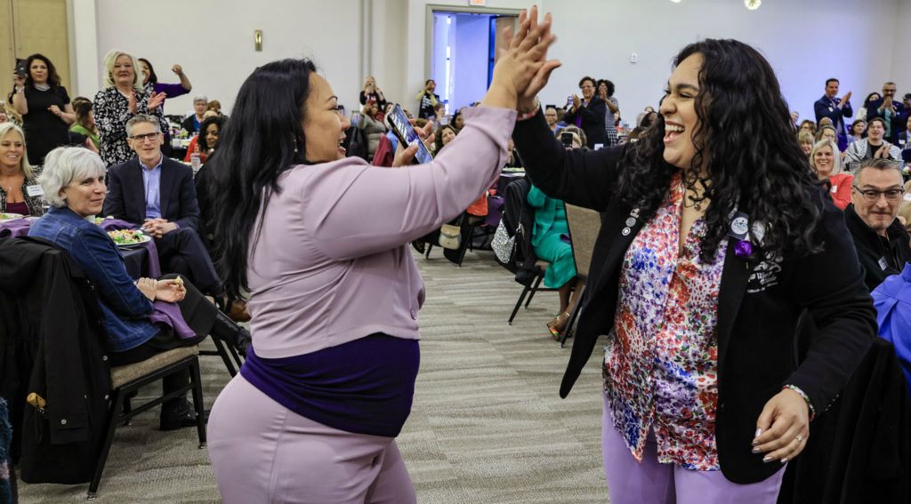 General News - 3rd place - Nina Corder (left) and Sierra Ortiz high five each other during the International Women's Day Signature Luncheon at the Hilton in Toledo.   (Jeremy Wadsworth / The Blade)