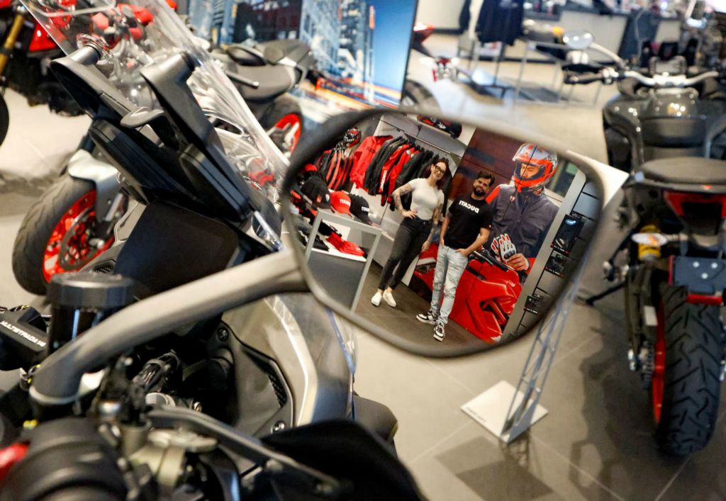 Portrait - 2nd place - Lexi Giesige, general manager, (left) and Kirk Edwards, CEO, are reflected in a rearview mirror as they pose for a photo in one of the showrooms at Rivers Edge Racing in Maumee,. (Kurt Steiss / The Blade)