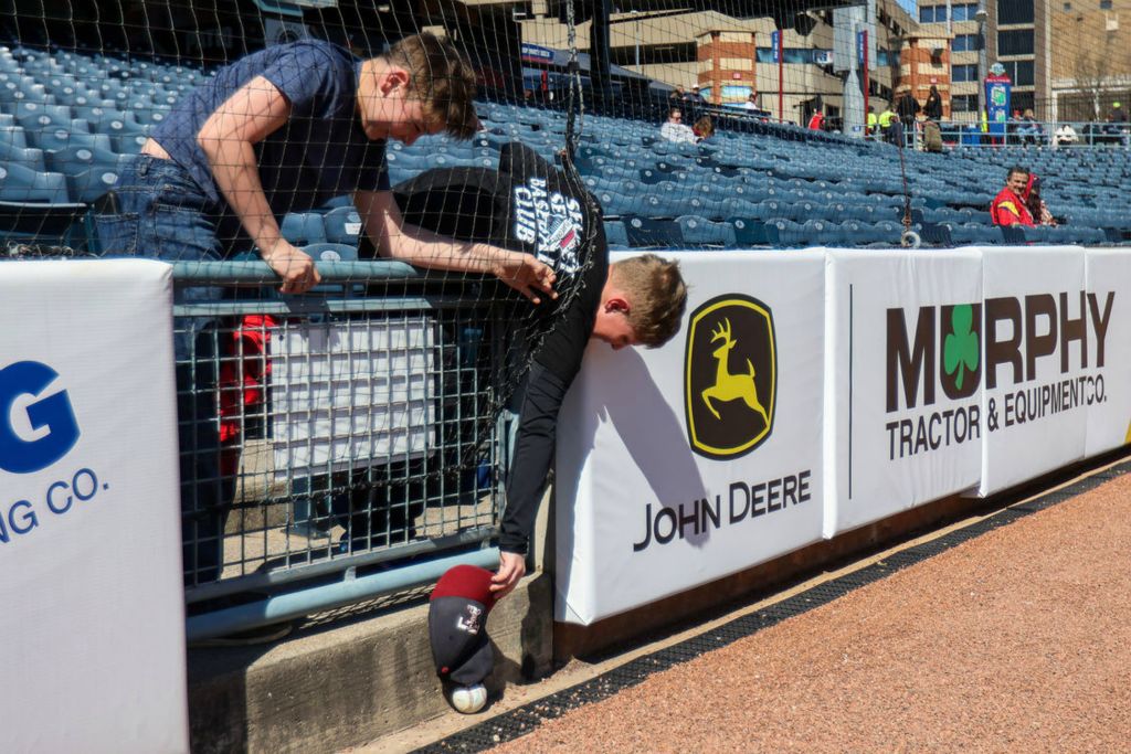 Sports Feature - 1st place - Connor Fought, 12, (right) uses his hat to reach a ball out of his and Jacob Woodruff’s reach during the Mud Hens opening day in downtown Toledo. (Rebecca Benson / The Blade)