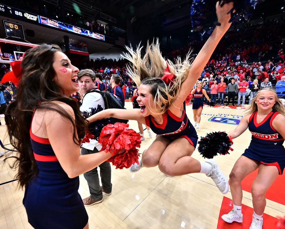 Sports Feature - HM - Dayton Cheerleader Annie Chiles jumps in celebration after the Dayton Flyers defeated VCU 91-86 in overtime at UD Arena in Dayton. (Erik Schelkun / Elsestar Images)