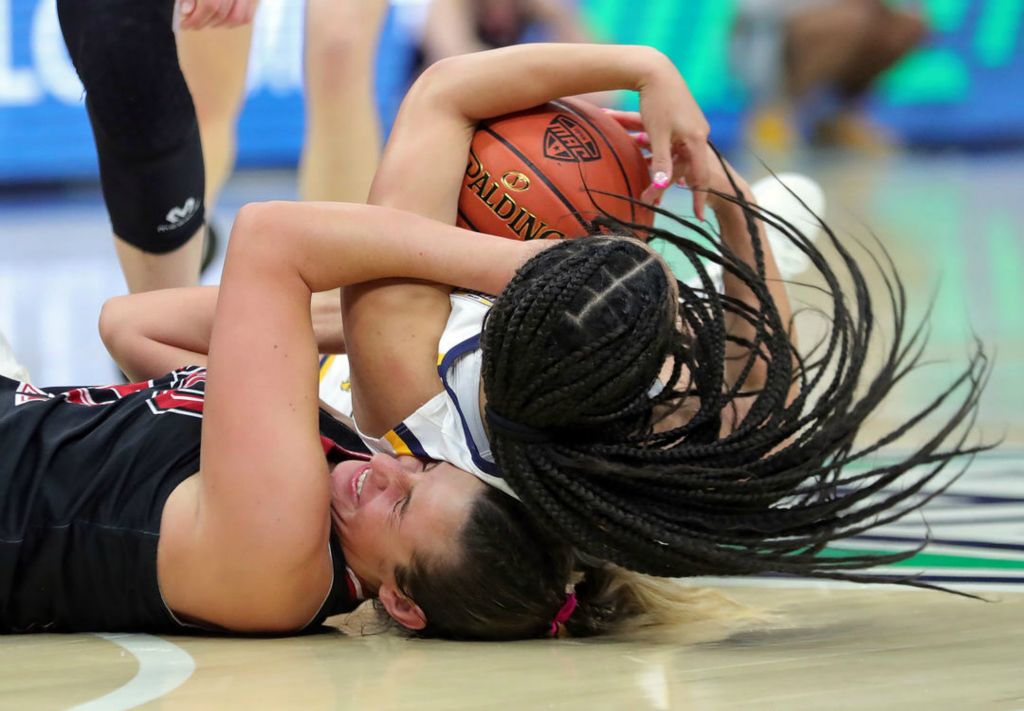 Sports - 2nd place - Northern Illinois forward Brooke Blumenfeld (41) wrestles with Kent State guard Dionna Gray (21) for the ball during the first half of a game in the quarterfinals of the Mid-American Conference Tournament at Rocket Mortgage FieldHouse in Cleveland. (Jeff Lange / Akron Beacon Journal)