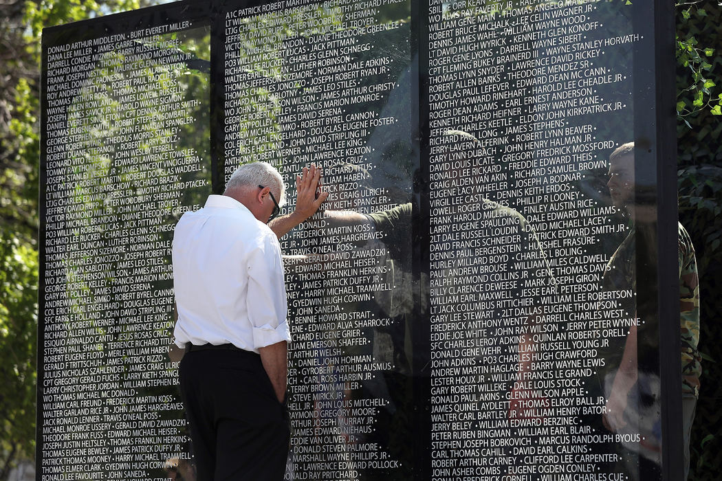 General News - 1st placeRex Fulk, of Hope Baptist Church, puts his hand on a memorial wall exhibit on the same spot of another's hand on the opposite side of the wall while it makes its way by truck down Jackson St. during the annual Toledo Memorial Day Parade.  (Amy E. Voigt/The Blade)