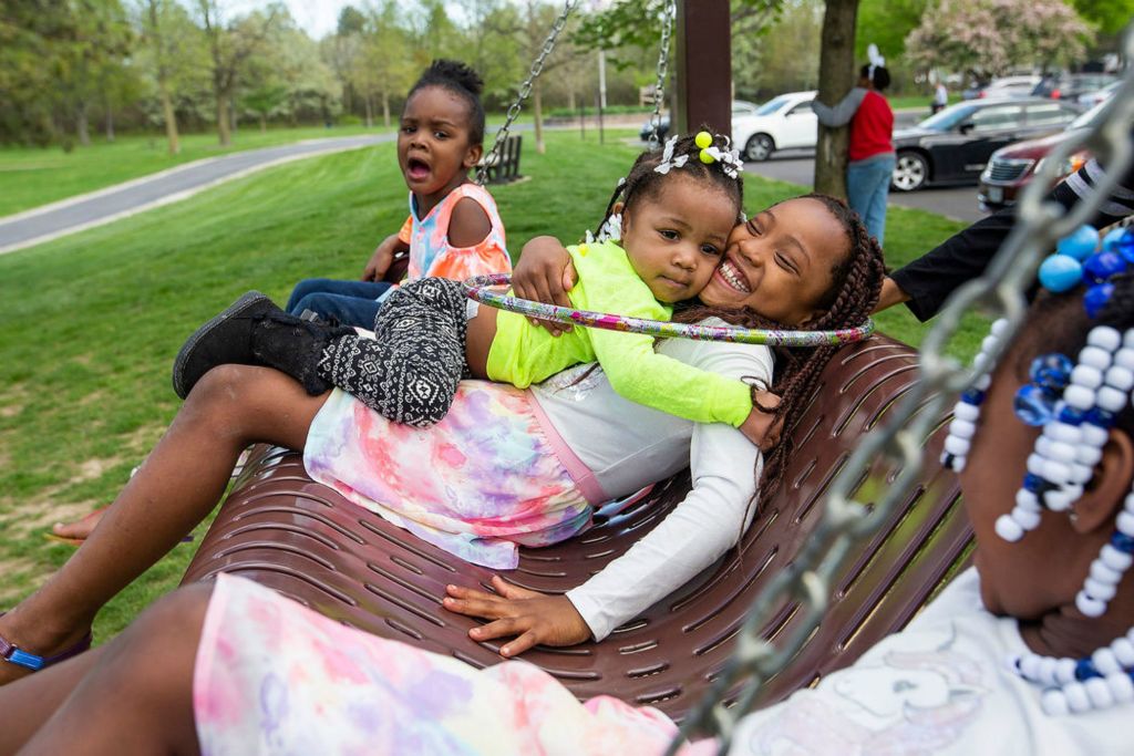 Feature - 1st place - Harley Kimbale, 4, (left) yells as Knowledge Williams, 2, (center) hangs on to Payton McMillen, 7, while playing on the swing at Swan Creek Metropark in Toledo. (Rebecca Benson / The Blade)