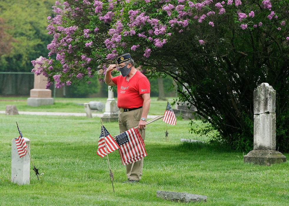 General News - 3rd place - Craig Gauger, an Air Force veteran who is part of the American Legion Post 28 and Veterans of Foreign Wars Post 6170, salutes after placing a flag at a veteran’s grave at Fort Meigs Cemetery in Perrysburg. (Kurt Steiss / The Blade)