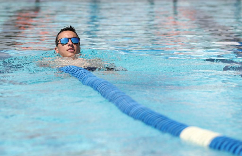 Lead lifeguard Tyler Mordarski installs the lane lines in a swimming pool at the Hilliard Family Aquatic Center in preparation for the pool's reopening.