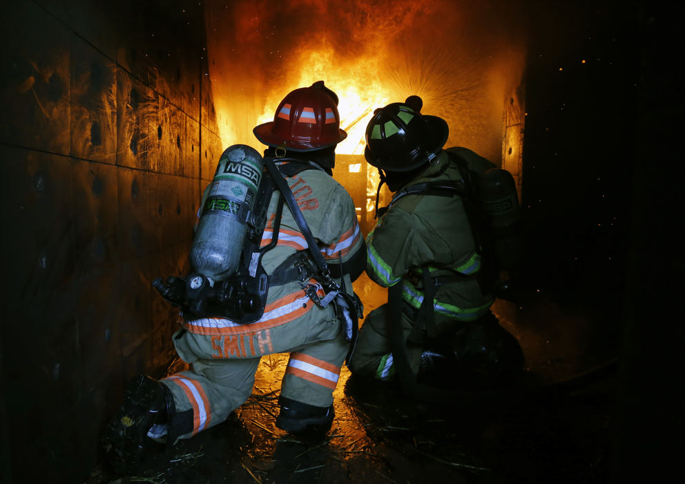 Columbus Division of Fire Assistant Chief Tracy Smith (left) teaches a student from Columbus State Fire Science the proper way to put out a fire during a live burn practice at Ohio Fire Academy in Reynoldsburg.