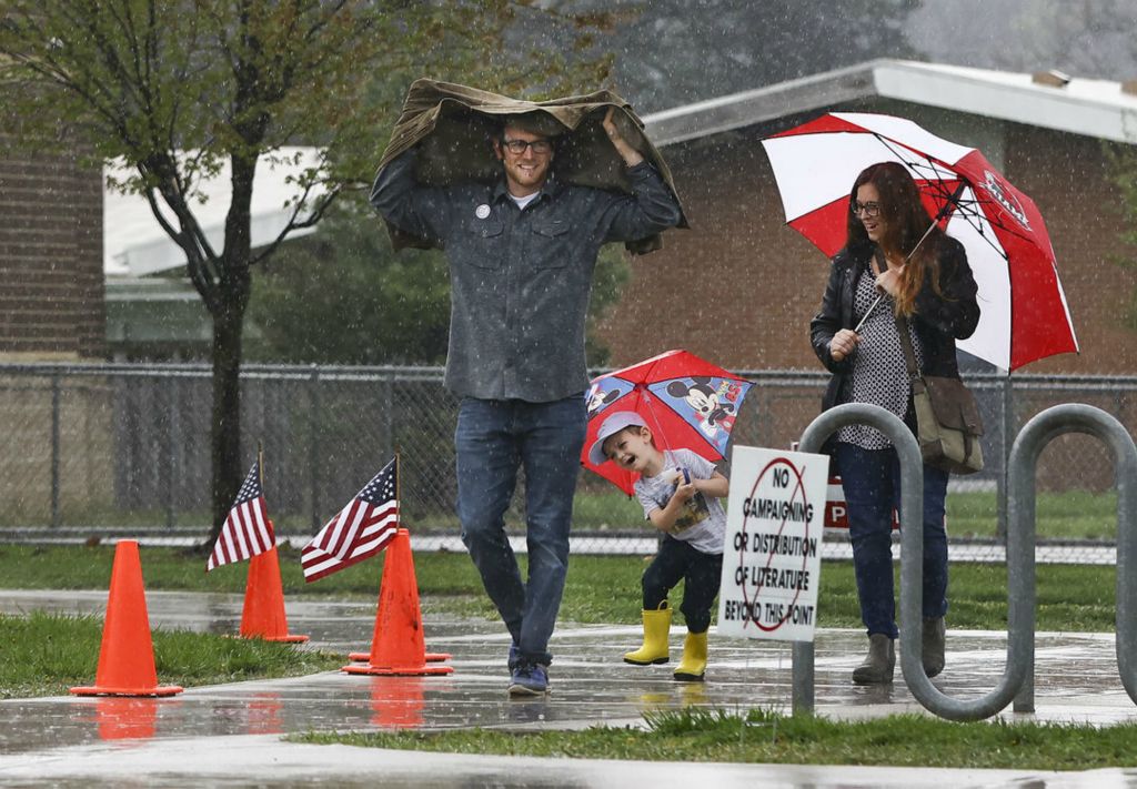 General News - 3rd place - Mitch Kaiser along with wife Cambra Kaiser and son Eijah, 4, head to their car in the pouring rain after voting Tuesday, May 3, 2022, at Old Orchard Elementary School in Toledo.  (Jeremy Wadsworth - The Blade)  