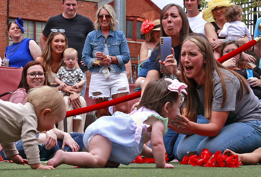 Feature - HM - Mother Stewart's Brewery held their first ever Crawl For the Roses as part of their Derby Day event celebrating the running of the Kentucky Derby. Instead of horses, however, Mother Stewart's race featured babies. Two heats of parents released their tiny thoroughbreds and cheered them on as they raced on all fours to the waiting arms of the other parent. Liam Zawada, 14-months, was the winner of the championship heat. He and his mother received an award for being the first Crawl for the Roses champion. (Bill Lackey / Springfield News-Sun)