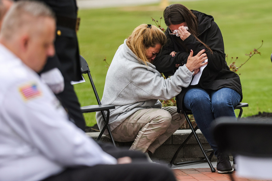 General News - HM - Benjamen Madrid’s sister Jessica Stoner (left) and her sister-in-law Kelly Madrid hug during a ceremony for the completed brick walkway leading into the institution at the Toledo Correctional Institution. The walkway has bricks with names of former wardens, correctional officers and memorials to officers that lost their lives.  (Rebecca Benson / The Columbus Dispatch)