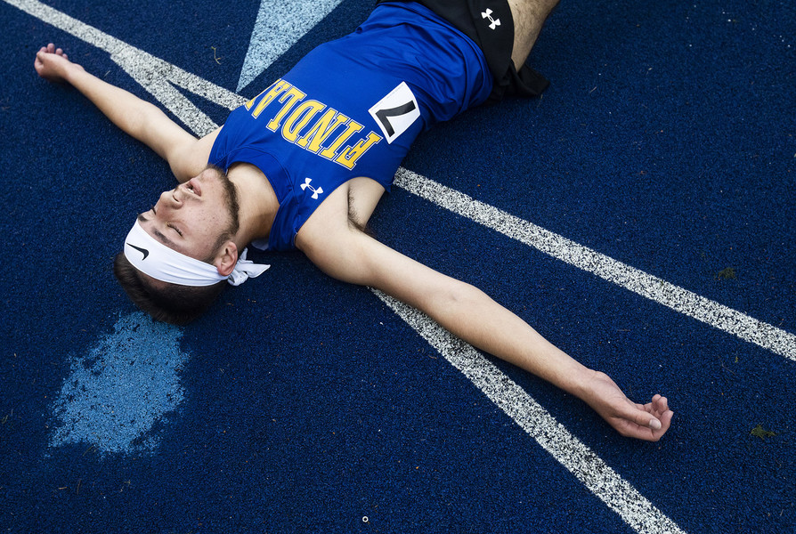 Sports Feature - 1st place - Findlay’s Preston Perkins lays on the ground after completing the 3200 meter run during the TRAC track and field championships at Findlay High School. (Rebecca Benson / The Blade)