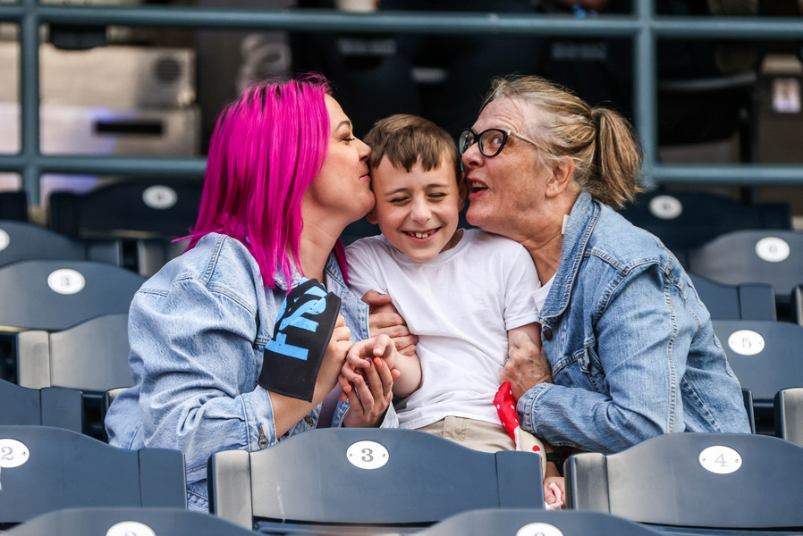 Sports Feature - 2nd place - Perrysburg resident Allie Cullum turns to peck Cameron Cardinale on the cheek with Sue Corbett during a kiss cam at a watch party as the Toledo Walleye face the Idaho Steelheads in the ECHL Western Conference Finals game three at Fifth Third Field in Toledo.  (Isaac Ritchey / The Blade)