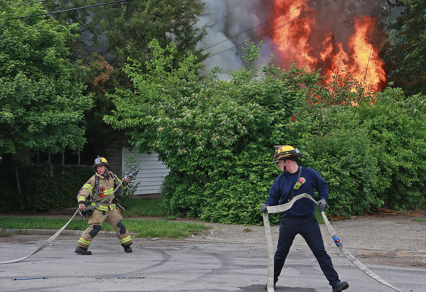 Spot News - 2nd place - The Springfield Fire Division responded to a fully involved vacant house fire in the 700 block of Tibbetts Avenue. The fire division arrived to find flames and smoke billowing out of the two story house that was surrounded by overgrown trees and shrubs. The Tibbetts fire was the second vacant house fire the Springfield Fire Division responded to Monday morning. Some of the fire units had to respond from a similar scene on Grand Avenue.  (Bill Lackey / Springfield News-Sun)