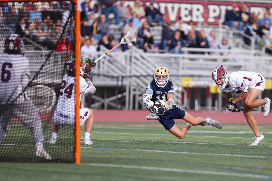 2nd -  Sports - 2nd place - St. John’s Jude Dzierwa takes a diving shot during a Division II regional lacrosse semifinal game against Rocky River at Rocky River High School. (Jonathan Aguilar / The Blade)   (Jonathan Aguilar / The Blade)