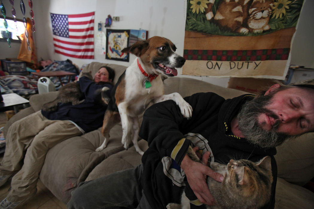 Portrait - HM - Karen Miller (left) holding Lil-8, with their dog T-Bone and Ronald Miller holding Neon in their Washington Court House home. Fayette County Humane Society Officers returned 3 cats to the Millers after they cleaned up their home. The third cat "Shy" in not in the picture.  (Tom Dodge / The Columbus Dispatch)