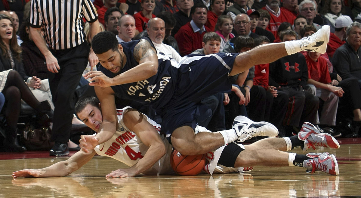 Sports - 2nd place - North Florida Ospreys guard Jimmy Williams Jr. (14) falls on top of Ohio State guard Aaron Craft (4) as they go for the loose ball in the first half of their NCAA basketball game at the Schottenstein Center. (Neal C. Lauron / The Columbus Dispatch)