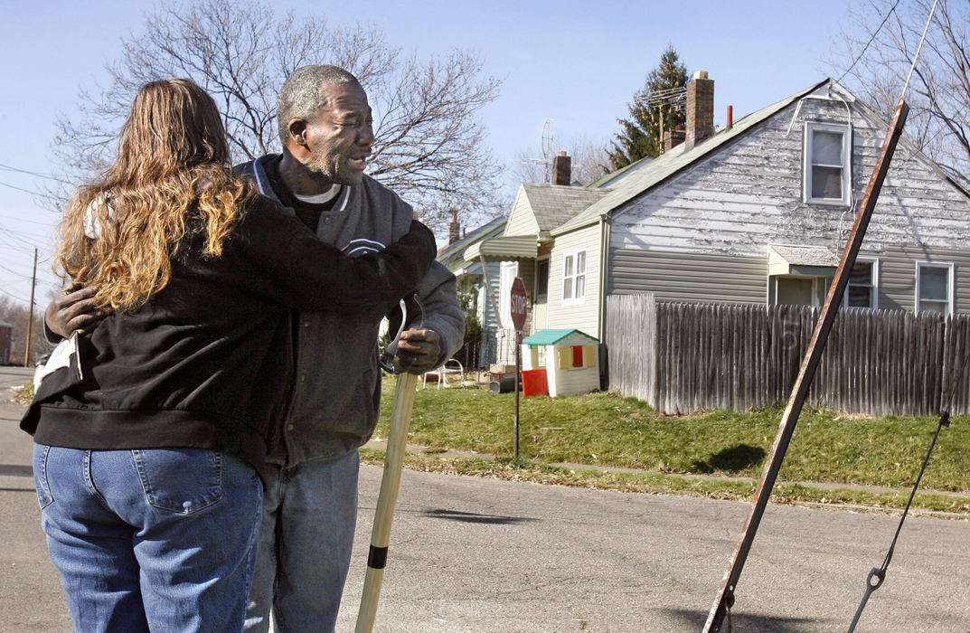 Spot News - 2nd placeTamera Swoveland-Raye (left) comforts Johnny McLeod, who had just learned of his friends death outside the home (background) of  Jeffrey Stutts Sr. who was shot and killed at the residence on 17th Street in Canton. (Scott Heckel / The Repository)