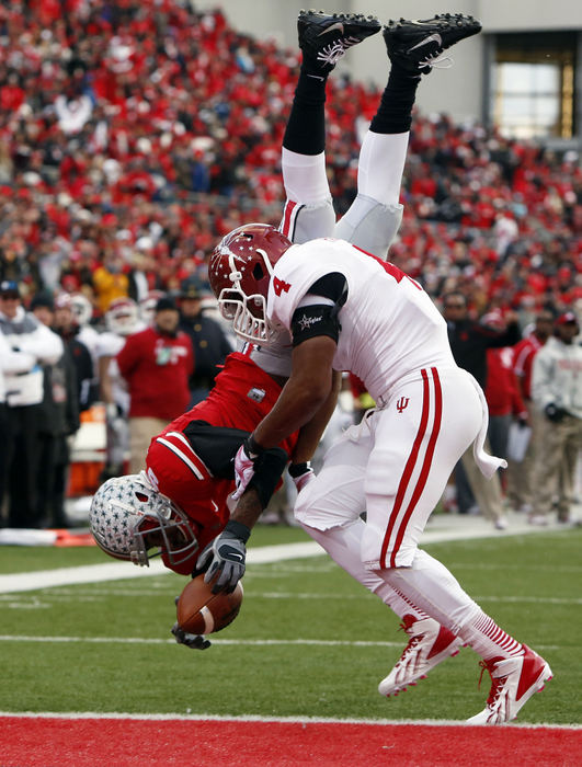 Sports - 1st placeOhio State quarterback Braxton Miller (5) flips into the end zone for a touchdown as he is hit by Indiana linebacker Forisse Hardin (4) in the second quarter during a game at Ohio Stadium in Columbus. (Barbara J. Perenic / The Columbus Dispatch)