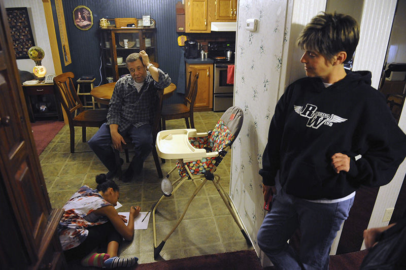 Feature - 3rd place - Mark Walker and Erin Walker watch as Mark's granddaughter, Deja Walker, 12, does homework at their Zanesville home. Deja, along with her siblings DaJean Walker, 11, and Cayerissa Walker, 7, live together with Walker and his wife. Racially diverse homes, such as the Walkers' are expected to increase in number in Muskingum County at a much higher rate during the next 50 years, according to data from a USA Today national study. (Shane Flanigan / Zanesville Times Recorder)