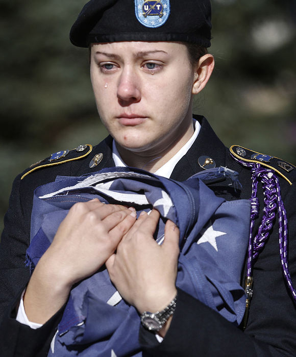 General News - 1st place - An emotional Michelle Janollari holds an American flag during the playing of the National Anthem, as the Student Veterans of America UT Chapter retires several American flags during a ceremony near the Student Union at the University of Toledo. The Avon, Ohio native said the event had a real emotional impact so close to Veteran's Day.   (Andy Morrison / The (Toledo) Blade)